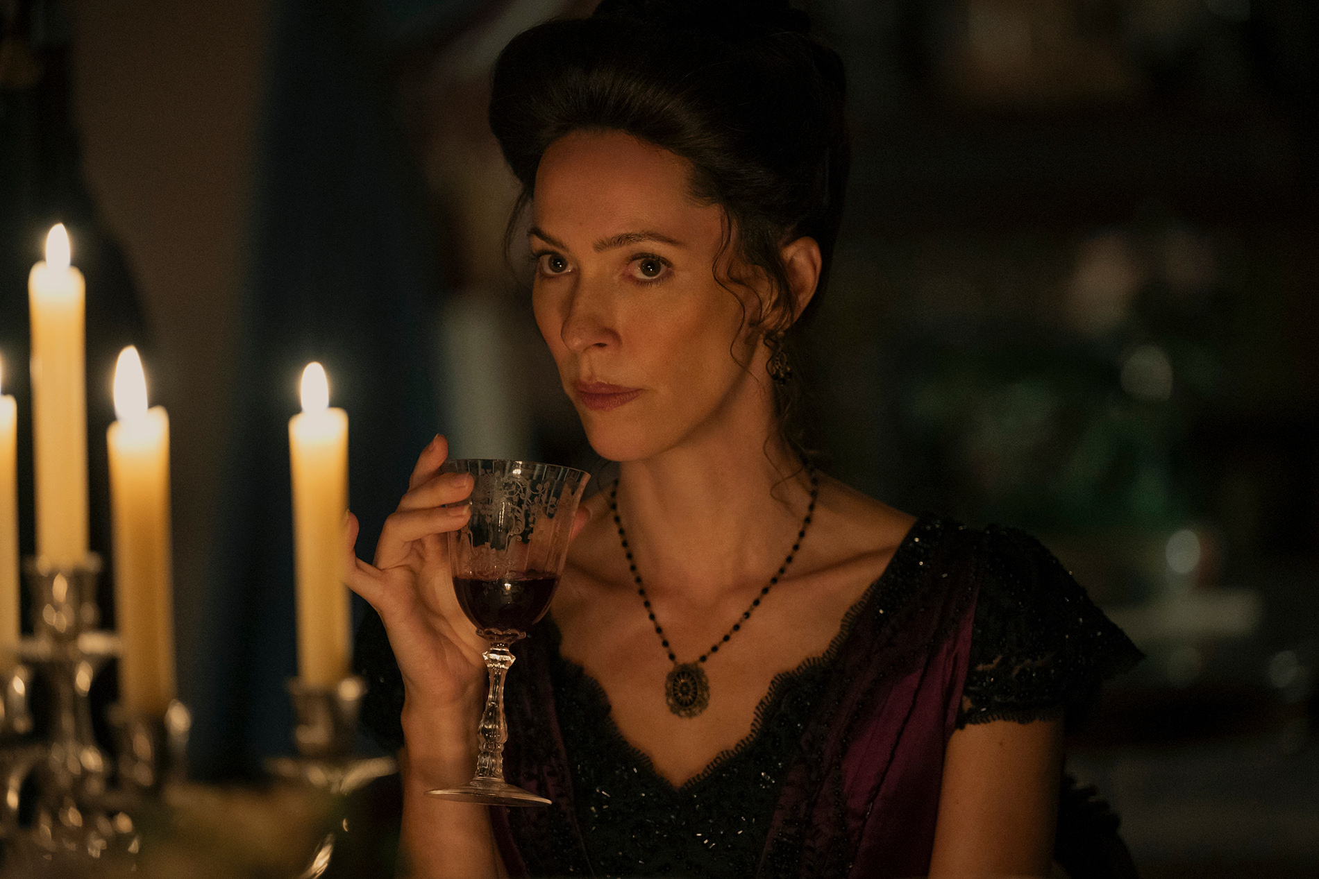 &Quot;Woman In Period Costume Sits At A Candlelit Table, Holding A Glass Of Red Wine, With A Serious Expression In A Dimly Lit, Elegant Room.&Quot;