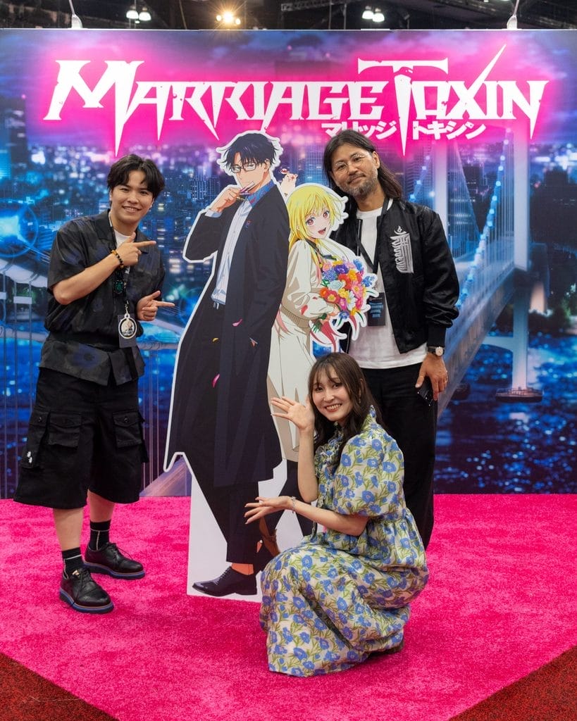 The MARRIAGETOXIN production staff standing next to cutouts of the show's main characters