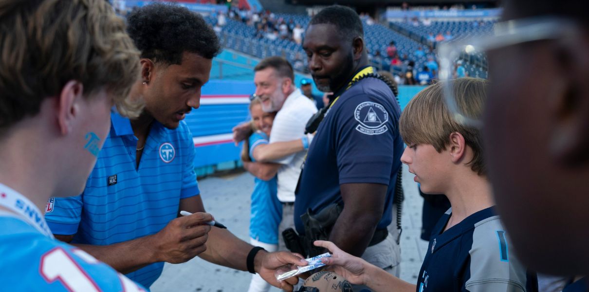 Elic Ayomanor, left, signs his rookie card for Tennessee Titans fan Max Tidwell, 13, of Nashville, Tenn., during the 2026 Titans Draft Party at Nissan Stadium Thursday, April 23, 2026.