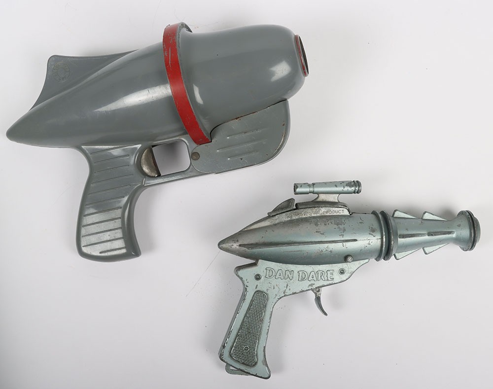 Lone Star Dan Dare Cap Firing Space Gun, diecast metal body, working mechanism, in good used condition. Approx L.20 cms (8 inches) Nu-Age Products Co. (USA) Smoke-Ring Space Gun, plastic/metal body, circa 1950s, in good used condition. Approx L.24 cms (9 ½ inches) (2 items)