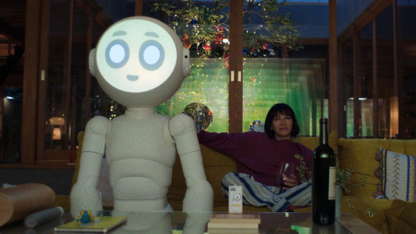 Rashida Jones and a robot hang out on a couch in dark comedy sci-fi series Sunny.