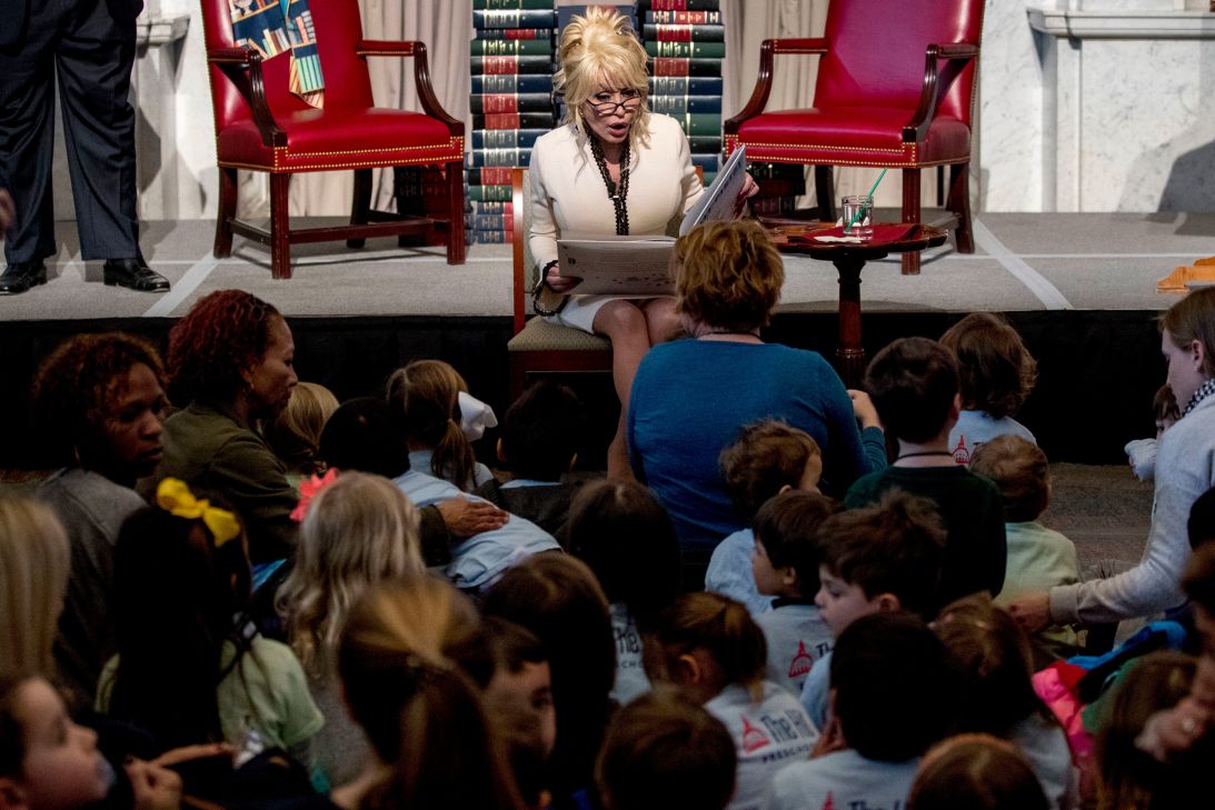 Singer-songwriter Dolly Parton reads her book "Coat of Many Colors," to children as she makes it the 100 millionth book that Imagination Library donates to the Library of Congress collection at the Library of Congress on February 27, 2018, in Washington, DC.