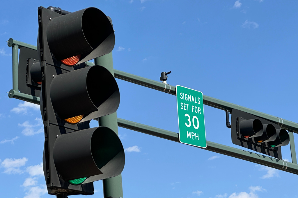 A sign notifies drivers that stoplights are set for a specific speed limit as part of the "rest on red" signal program in Albuquerque, N.M., Wednesday, Aug. 12, 2026.