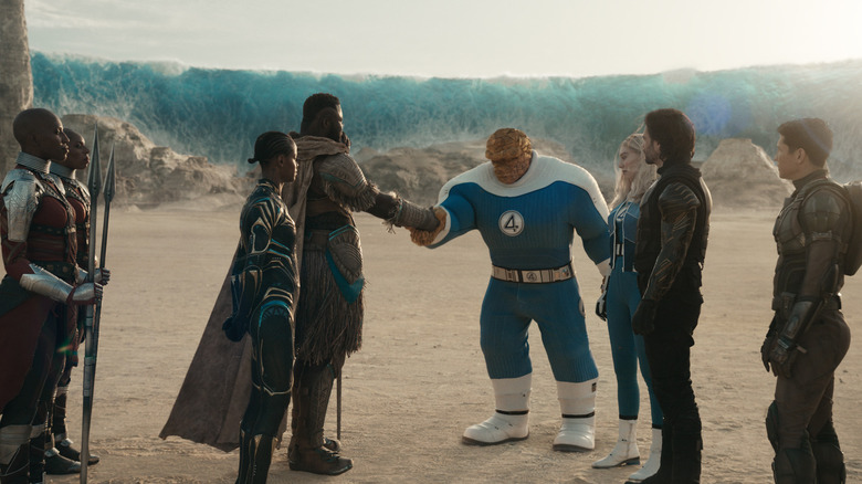 Winstone Duke as M'Baku shaking hands with Ebon Moss-Bacharach as Ben Grimm while other superheroes look on in Avengers: Doomsday