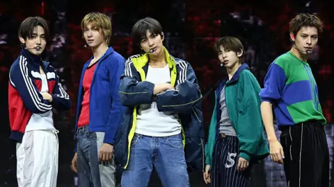 Imazins via Getty Images Five members of Cortis pose on stage, wearing bright-coloured outfits