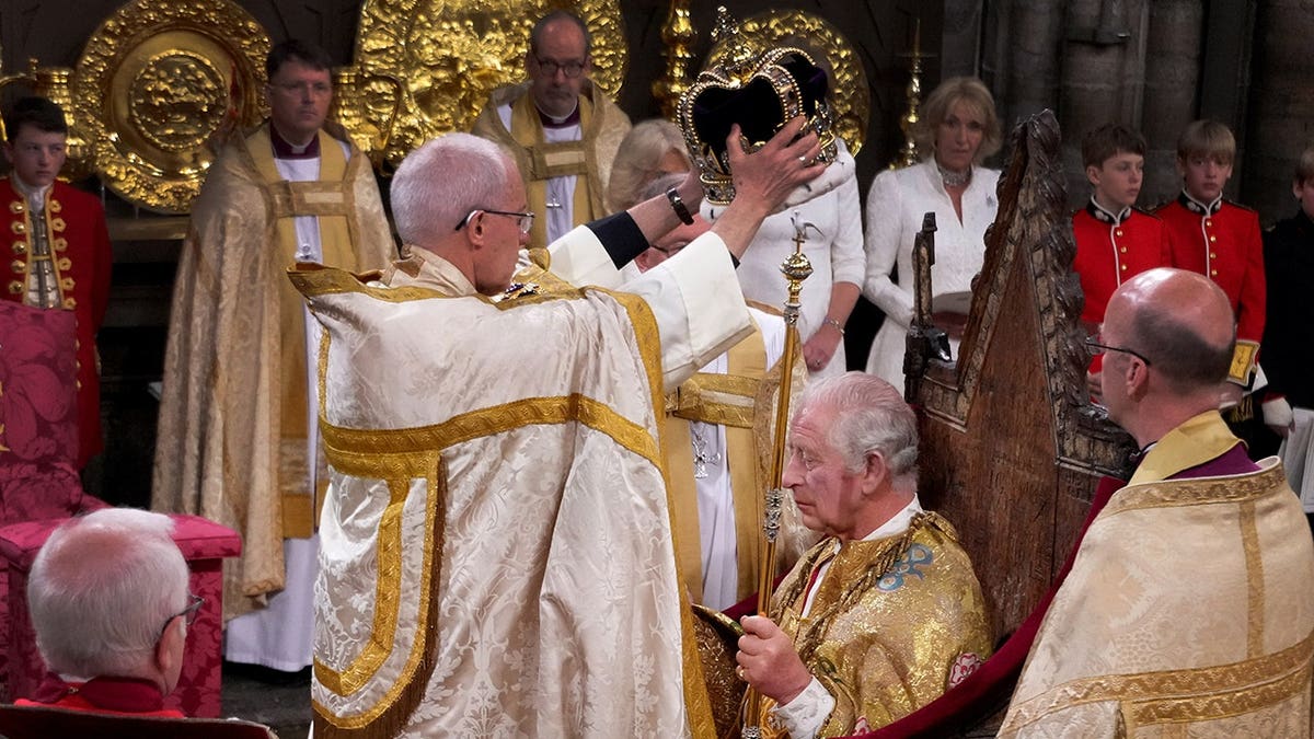 King Charles III is crowned with St. Edward's Crown by Archbishop Justin Welby at Westminster Abbey.