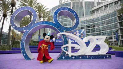 Mickey Mouse poses outside the entrance to D23: The Ultimate Disney Fan Event