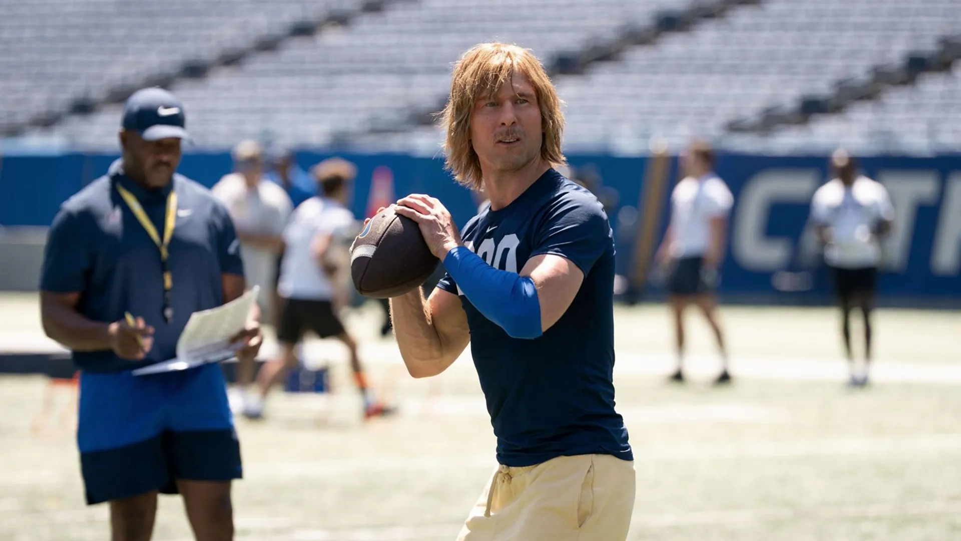 Chad Powers (Glen Powell) prepares to throw the football in training.