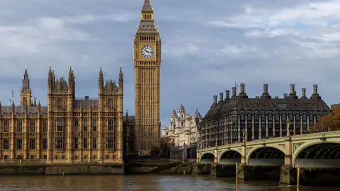 Getty Images The Elizabeth Tower, known as Big Ben, and the Palace of Westminster beside the River Thames, with Westminster Bridge in the foreground under cloudy skies.