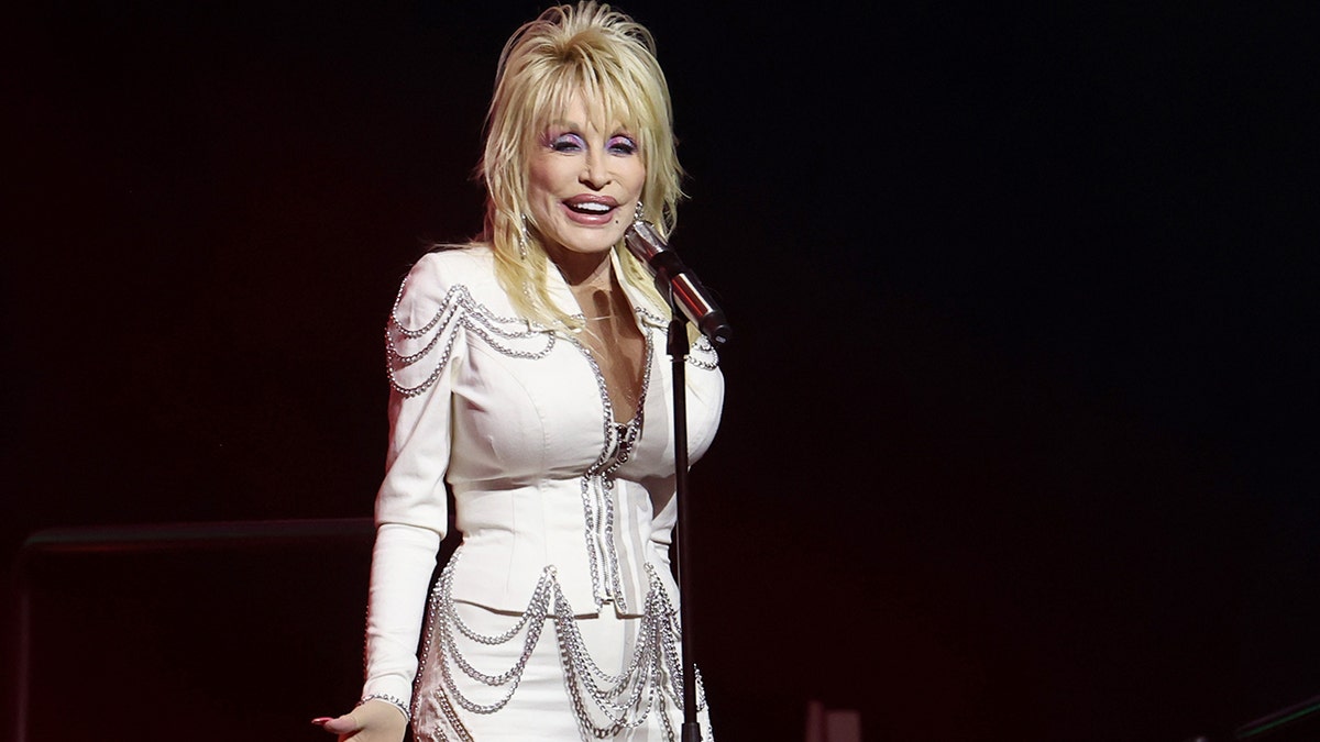 Dolly Parton wearing white on stage in 2024.