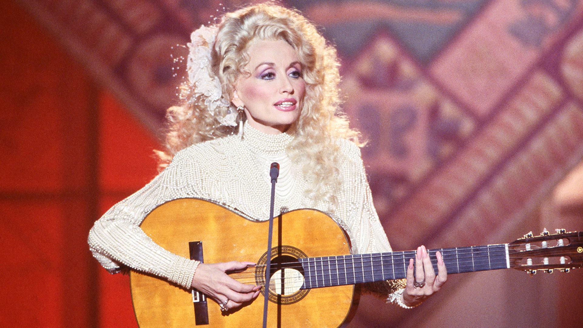 Dolly Parton on stage in white in 1978.