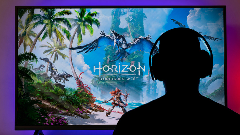 A person looking at "Horizon Forbidden West" while wearing a pair of headphones