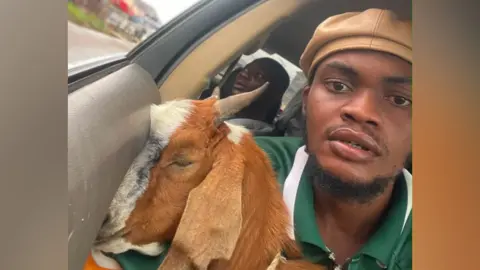Courtesy of Promise Okoro Promise Okoro poses for a selfie in a car with his goat.