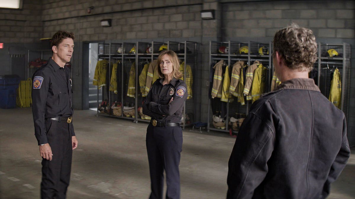 Michael Trucco as Luke Leone and Diane Farr as Sharon Leone stand together in a scene from Fire Country.