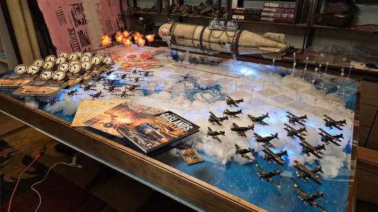 The game table, models, and accessories needed to play a custom game of Gaslands themed around Crimson Skies - biplanes and a massive blimp