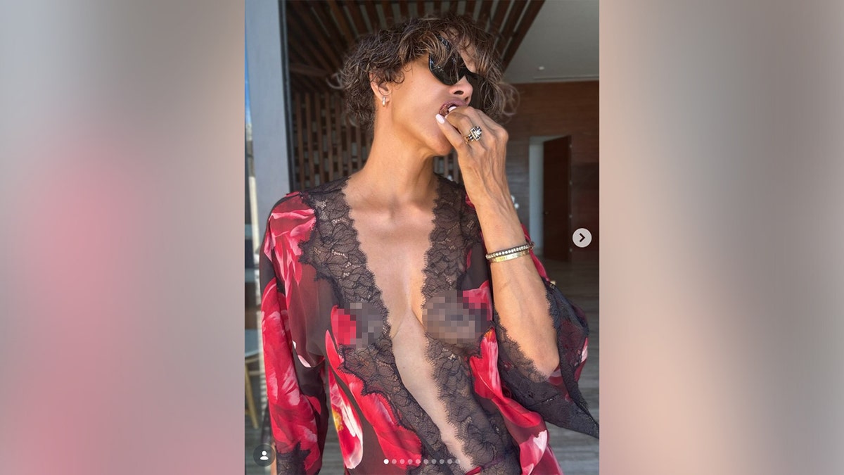 Halle Berry in a black robe with red florals on it