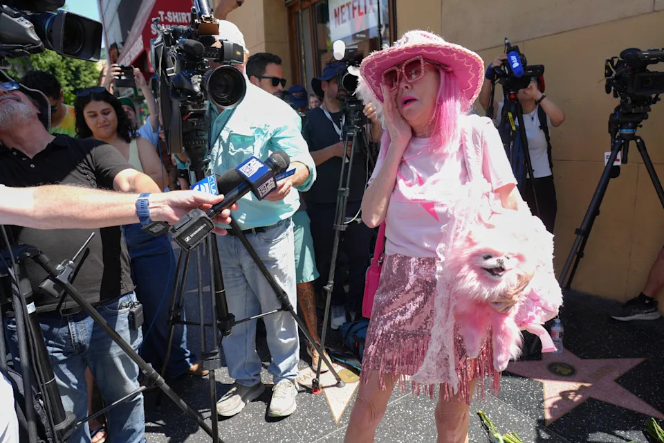 Kitten Kaysera with dog Pinky interviewed at Dolly Parton's star on the Hollywood Walk of Fame, Aug. 25, 2026, in Los Angeles. (AP Photo/Chris Pizzello)