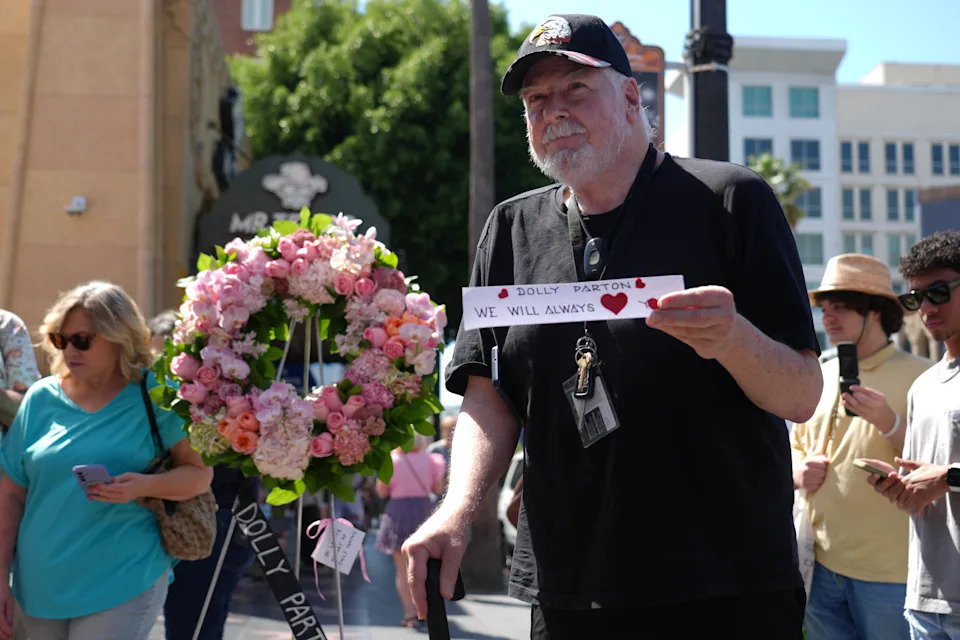 Killy Phan holds a message at Dolly Parton's star on the Hollywood Walk of Fame Tuesday, Aug. 25, 2026, in Los Angeles. (AP Photo/Chris Pizzello)