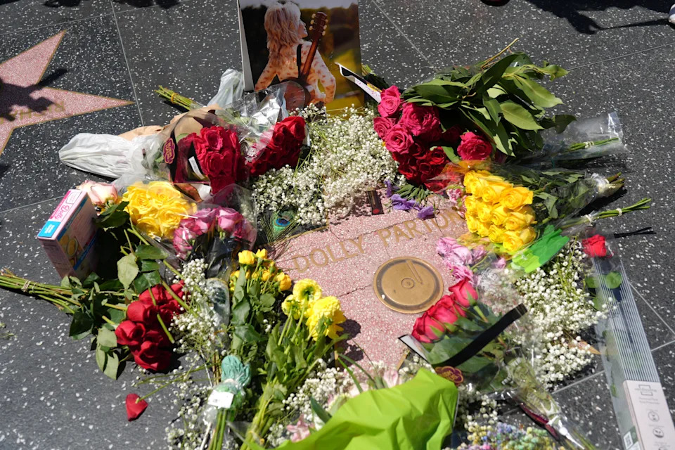 Dolly Parton's star on the Hollywood Walk of Fame is decorated with flowers Tuesday, Aug. 25, 2026, in Los Angeles. (AP Photo/Chris Pizzello)