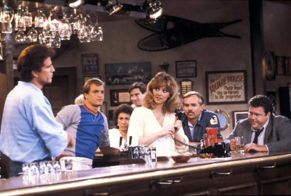 The ensemble cast of Cheers gathered at the bar on the show's Boston set