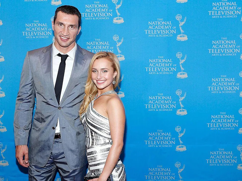 Wladimir Klitschko in a grey suit, white shirt and black tie is pictured smiling with his arm around Panettiere, who is smiling and has long blonde hair and wears a silver and white halterneck dress at an Emmy Awards reception in 2013.