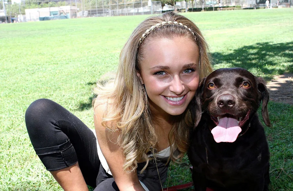Hayden Panettiere, wearing a headband and smiling, poses for a portrait with her pet dog Penny Lane during a photo shoot at La Cienega Park in Beverly Hills, CA on July 22, 2006.