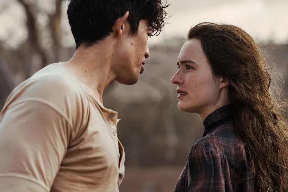 Man and woman (Christopher Chung and Phillipa Northeast) facing each other, man in beige shirt, woman in plaid shirt.