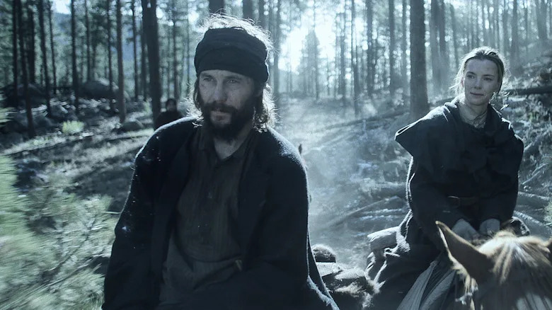 Isaac and Sara on horseback in the woods in American Primeval
