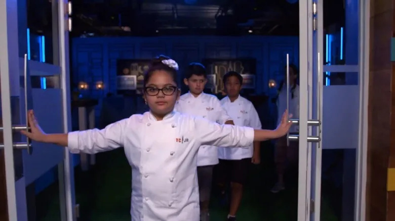 4 small children in white chef's jackets that say