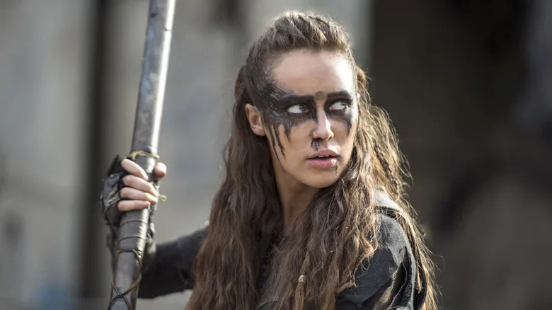 Lexa holding a long pole and turning in surprise in "The 100"