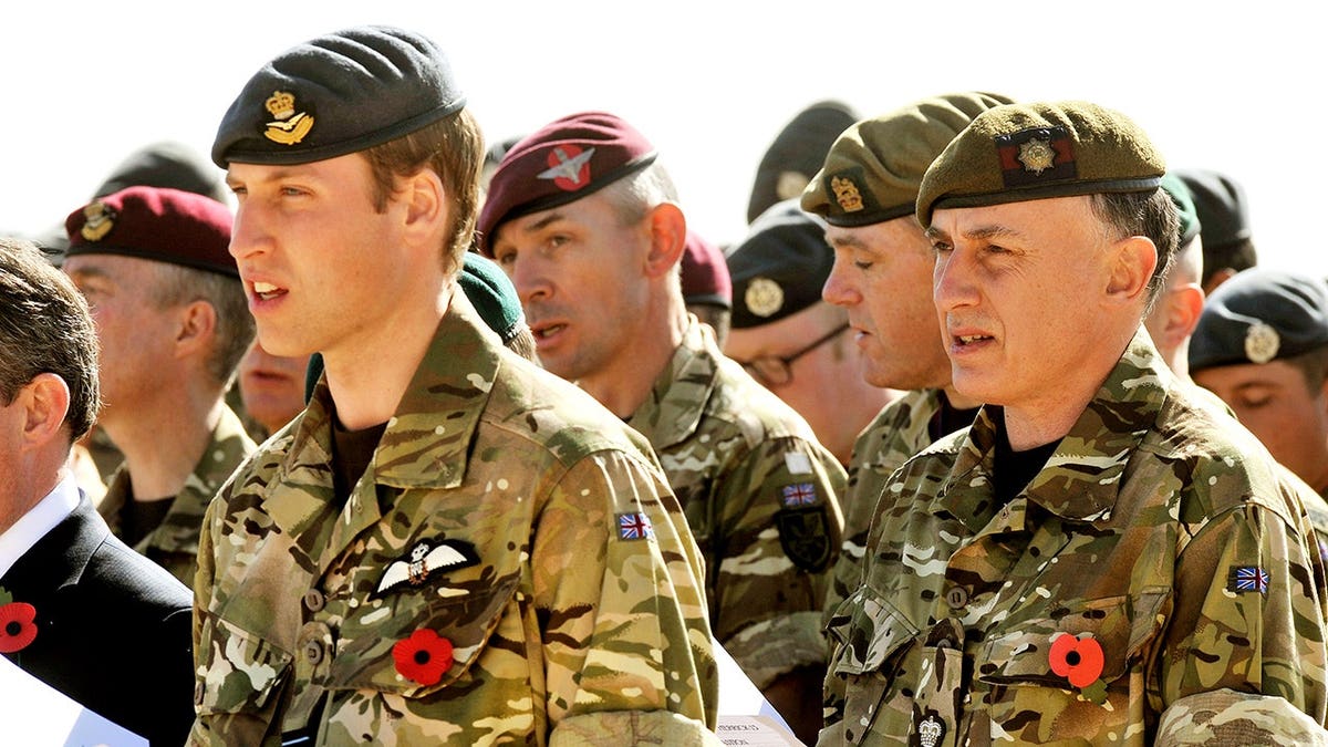Jamie Lowther-Pinkerton stands behind Prince William during a Remembrance Day service.