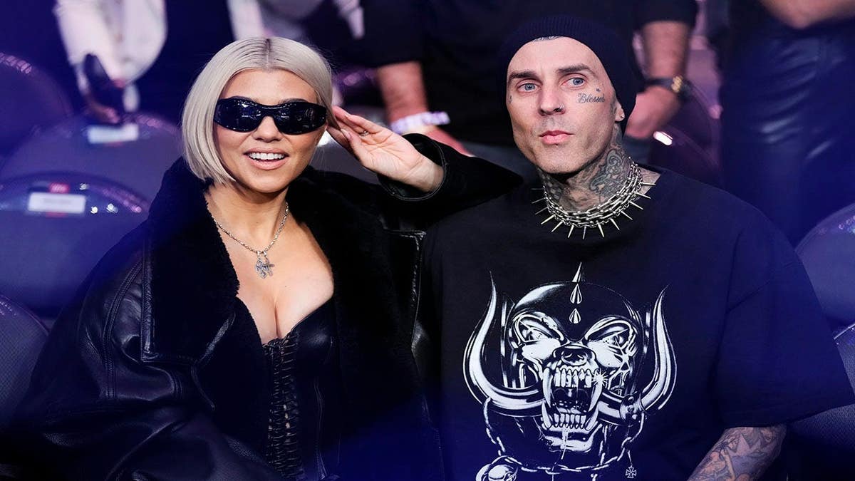 Kourtney Kardashian and Travis Barker standing together at UFC 285 event in Las Vegas