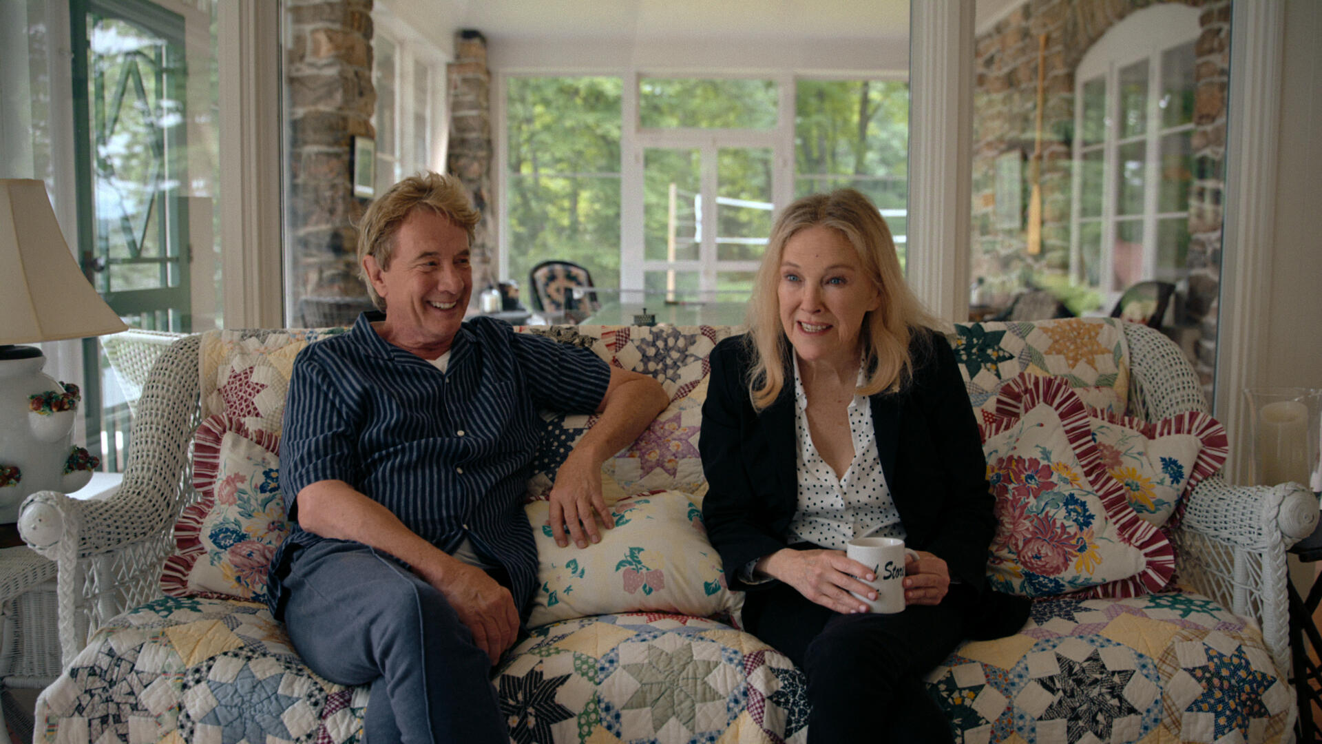 Martin Short sits next to Catherine O'Hara on a couch