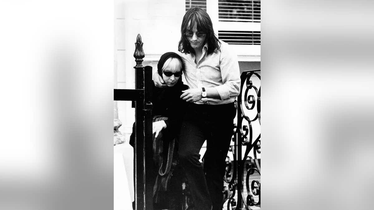 Monika Dannemann is helped up the steps of a building where Jimi Hendrix died.
