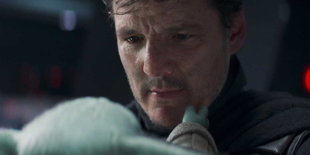 Din Djarin (Pedro Pascal) holding Grogu in 'The Mandalorian'