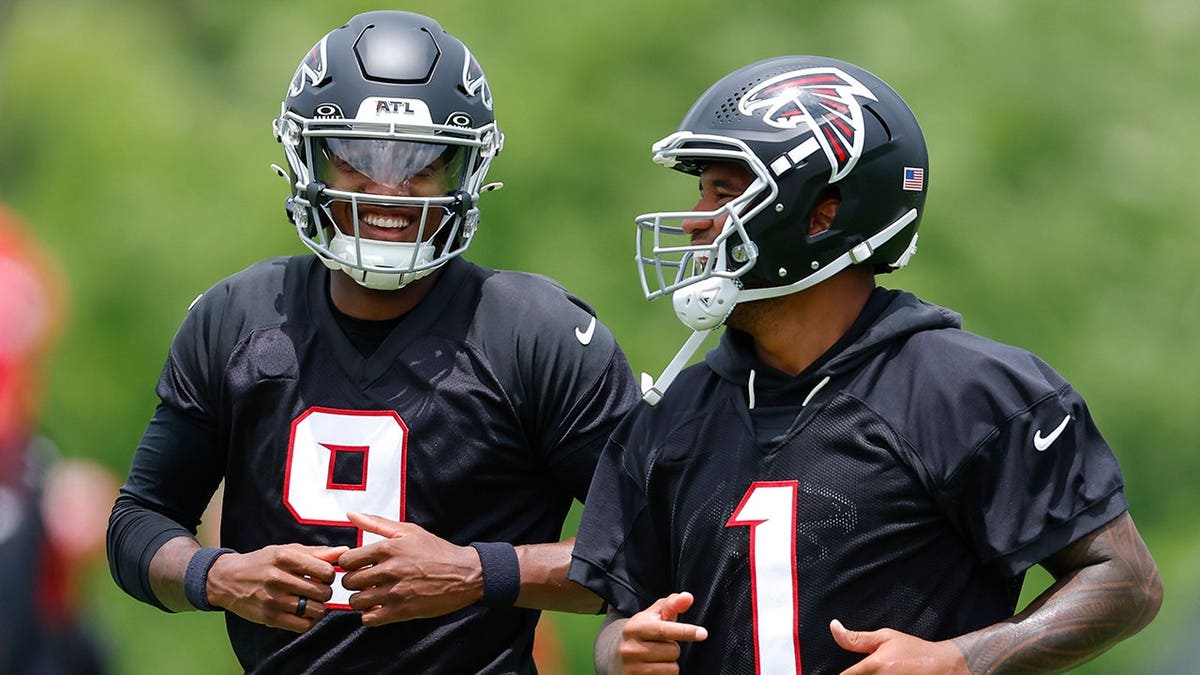 Michael Penix Jr. and Tua Tagovailoa laugh during OTAs at IBM Performance Field.
