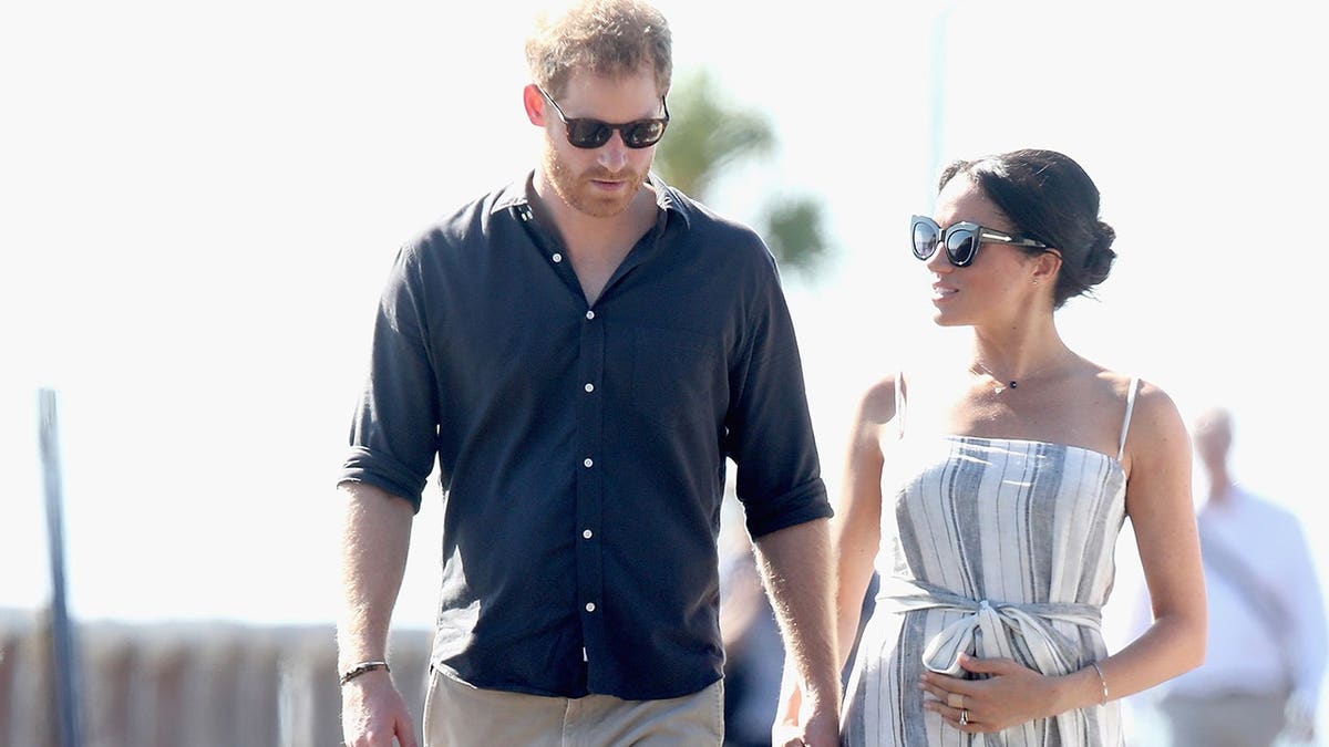 Prince Harry and Meghan walk along Kingfisher Bay Jetty in Fraser Island, Australia.