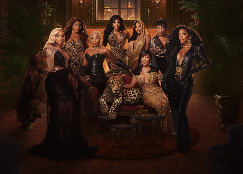 The full RHOA Season 17 cast standing in a room with brown decor.