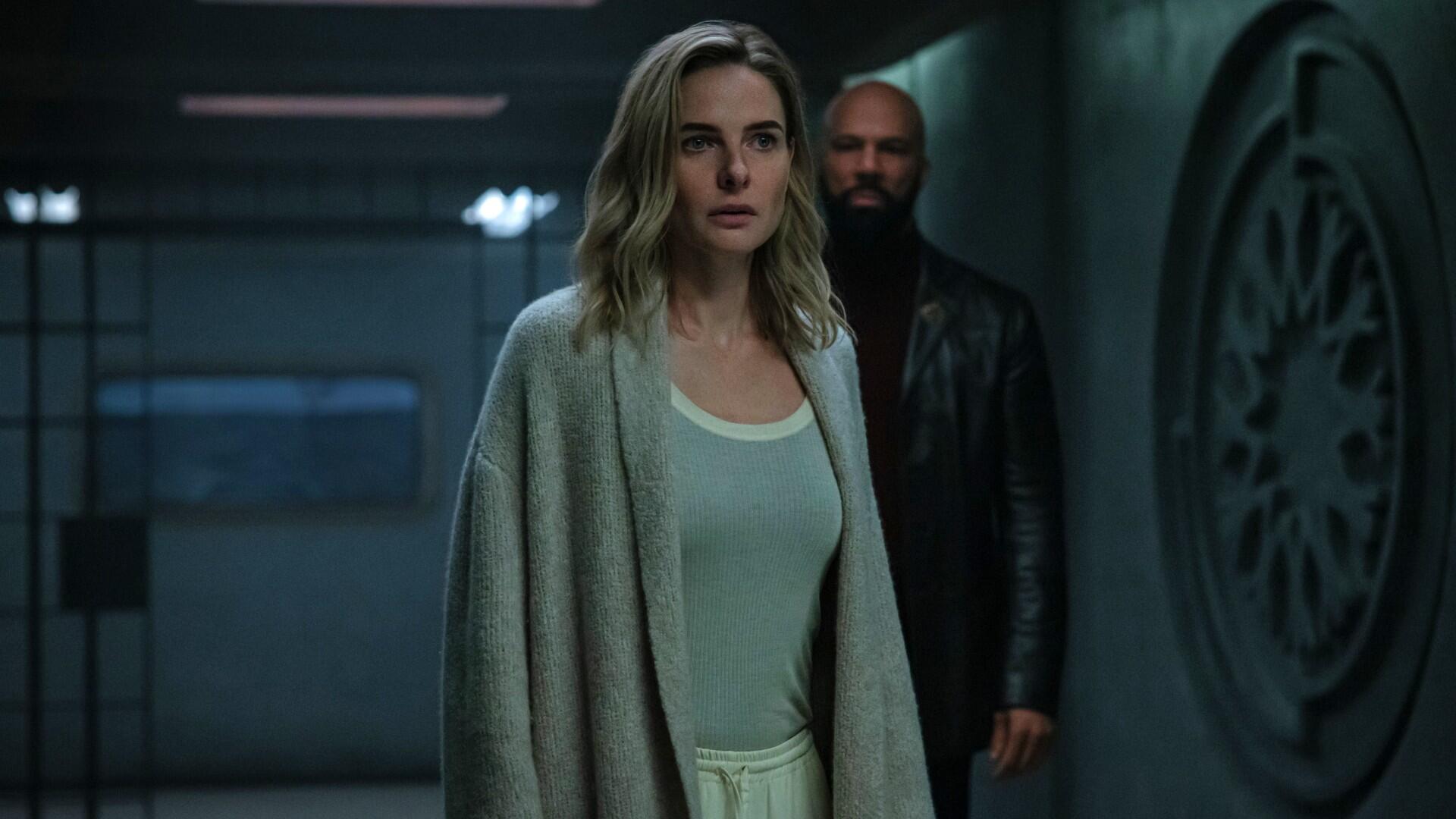 Production still from Silo showing Rebecca Ferguson and Common standing in a corridor.