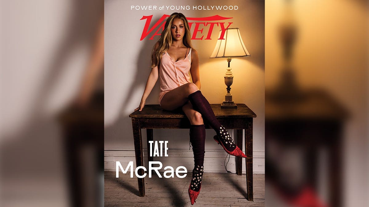 Tate McRae sits on a desk
