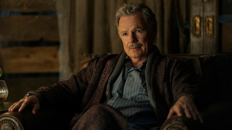 Bruce Greenwood sits in an armchair in "The Fall of the House of Usher"