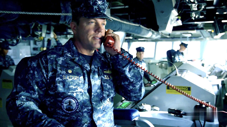 Mike Slattery in a camouflage uniform talking on a red phone in The Last Ship