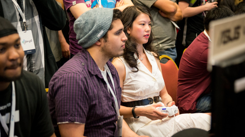 A man and a woman using GameCube controllers at a video game tournament