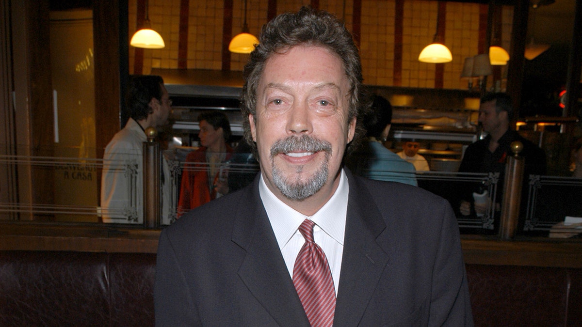 Tim Curry smiles for the camera at a restaurant in NYC.