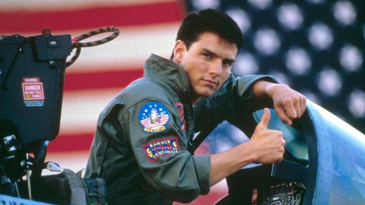 Tom Cruise giving a thumps up inside a fighter jet