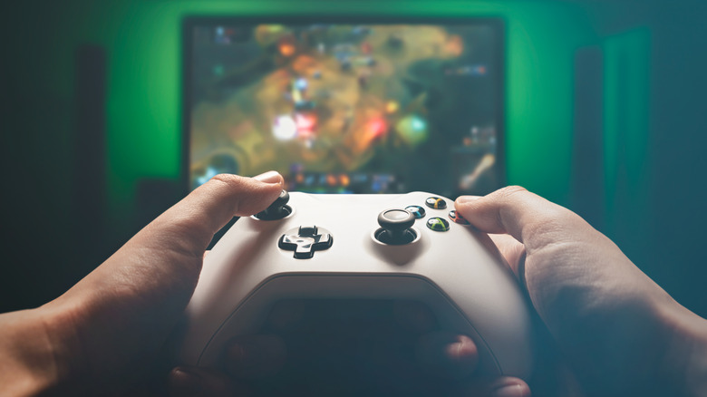 Close up of someone playing a video game using an Xbox controller