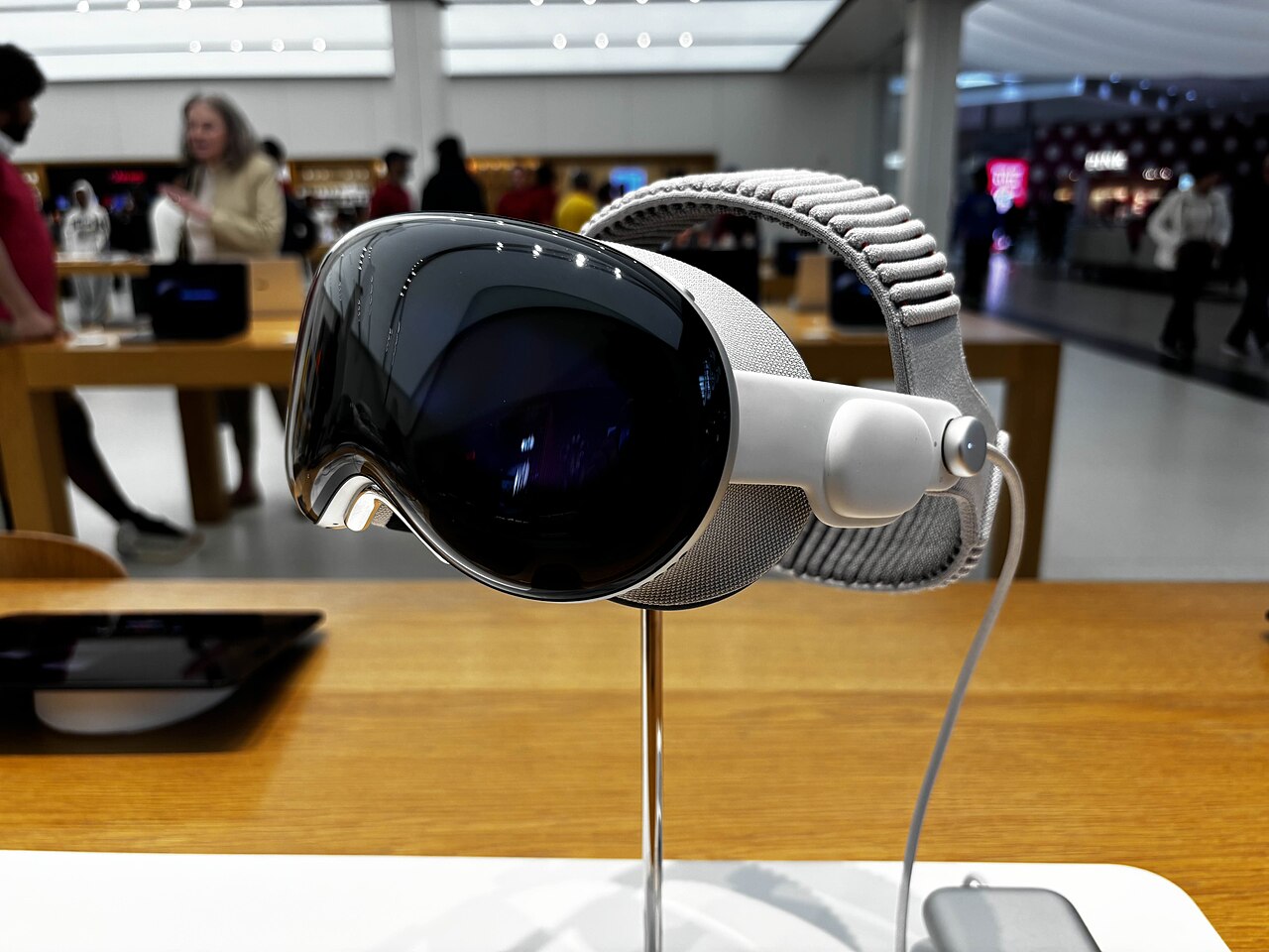An Apple Vision Pro with Dual Knit Band on a demo stand inside an Apple Store