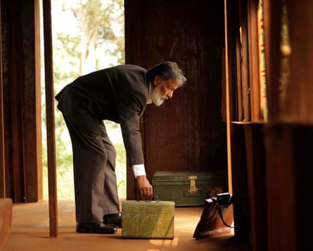 A man bending to pick up a briefcase
