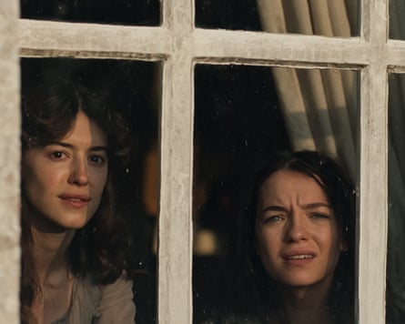 Two women looking out of a window.