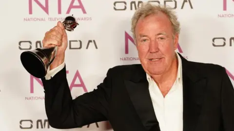 PA Media Jeremy Clarkson holding an award in the air